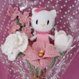 Heklani buket sa motivom poznate bele mace u roze haljinici, sa cvetovima u roze i beloj boji